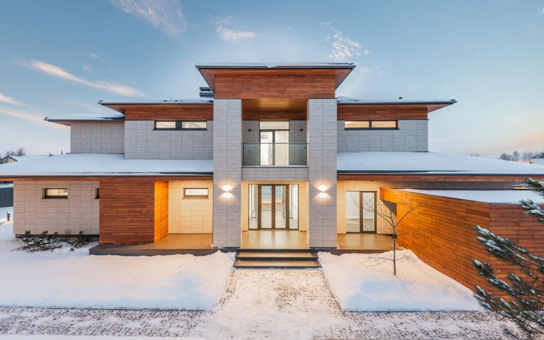 a large house surrounded by snow with cleared walkways—a way to make your property stand out this winter