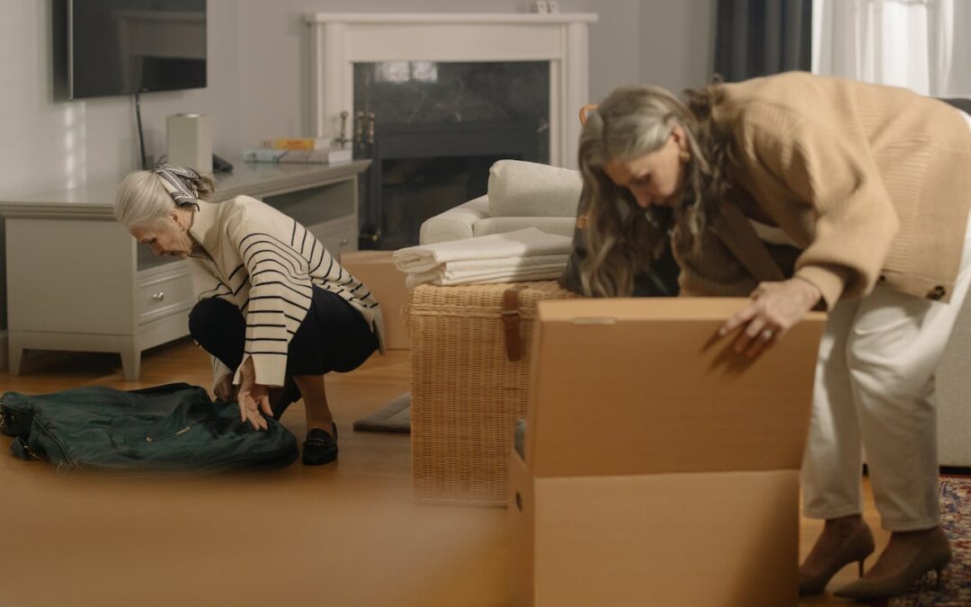 Two older women packing for the move