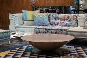 Vibrantly-hued sofa beside a circular coffee table.